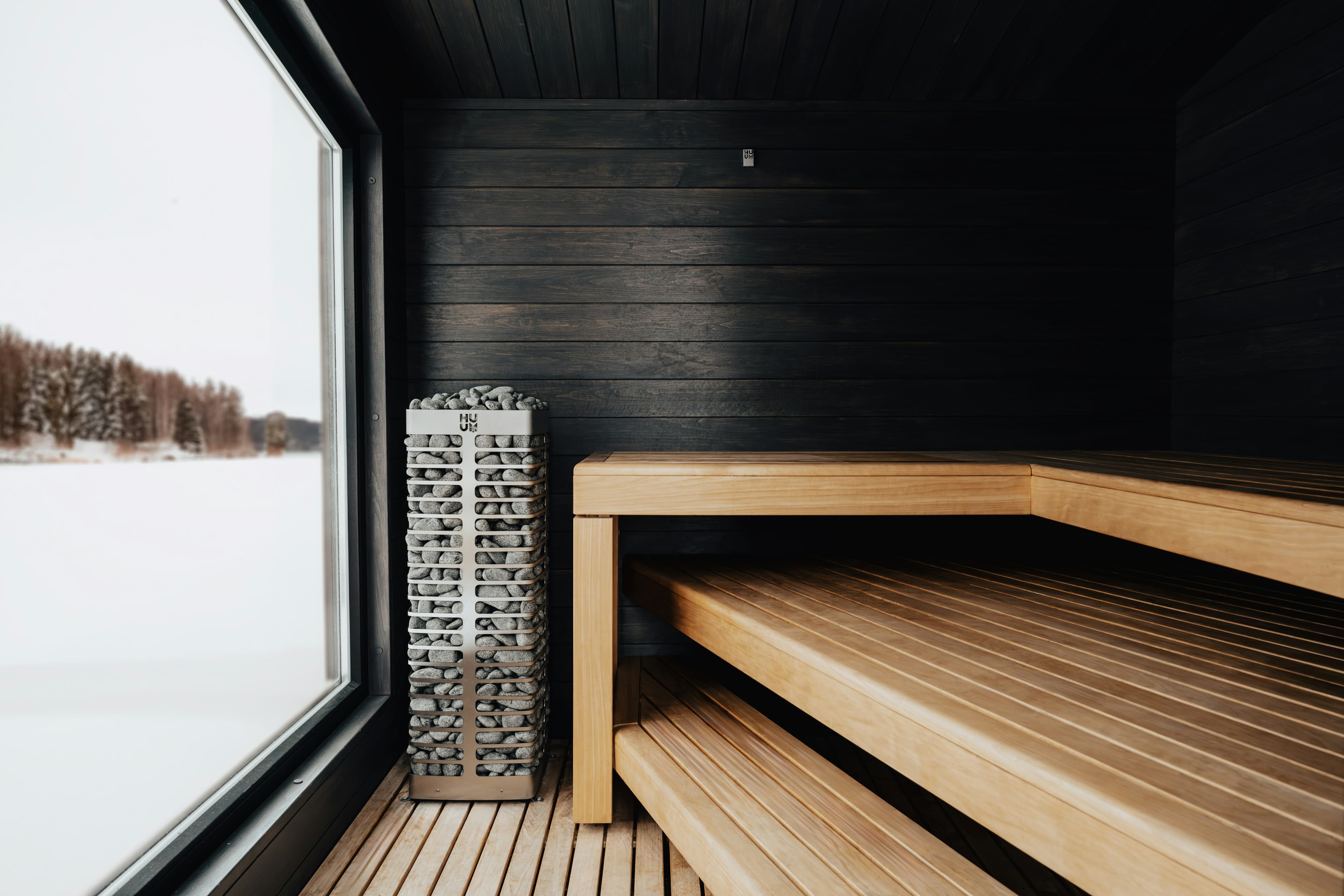 Modern Finnish sauna interior with panoramic winter lake view