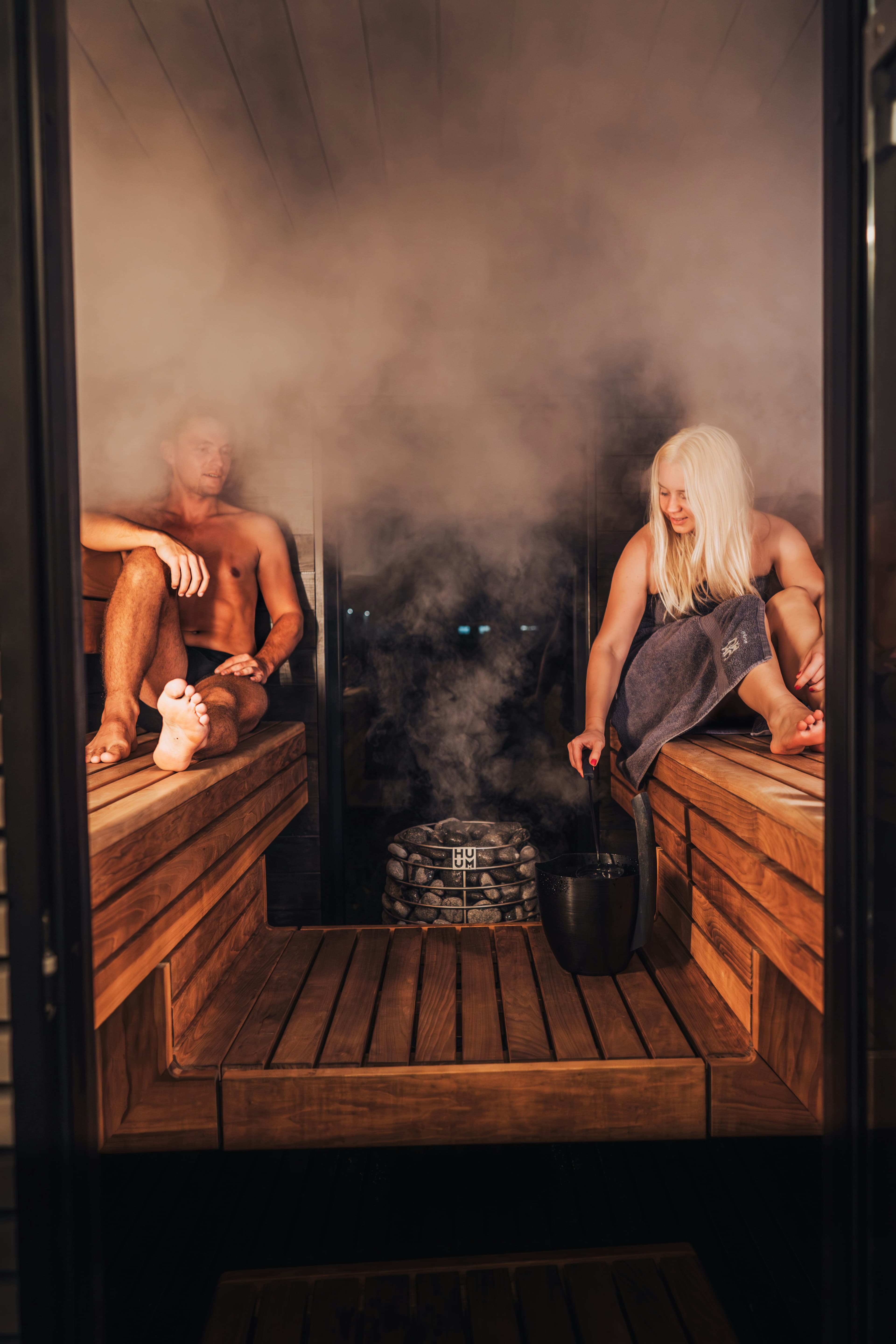 Two people enjoying löyly steam in a Finnish sauna