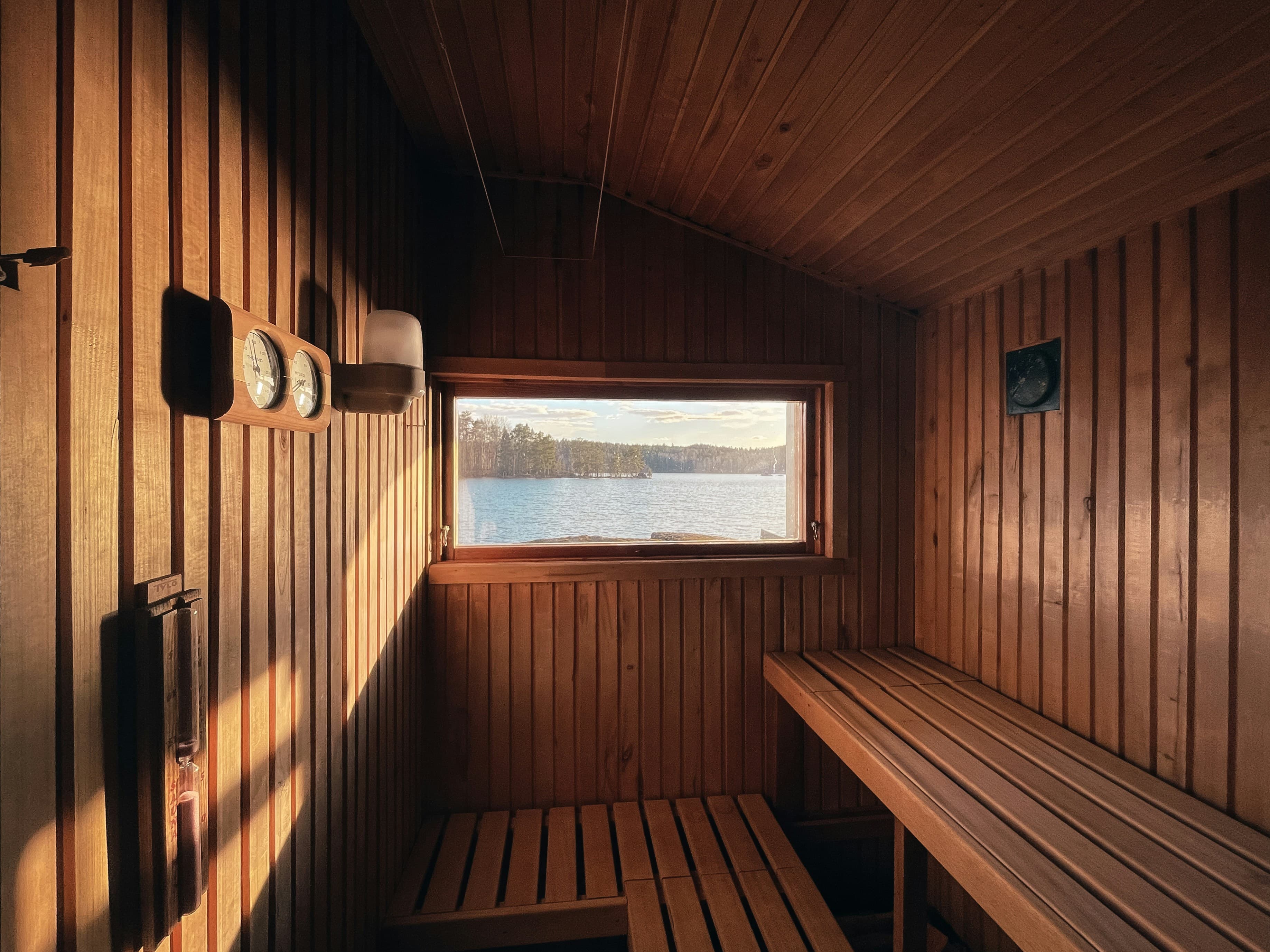 Finnish lakeside sauna interior with panoramic window view over a lake